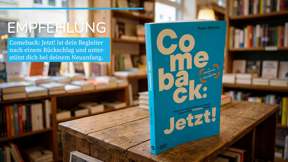Aktuelles Buch "Comeback: Jetzt! Wie du nach einem Rückschlag schnell wieder auf die Erfolgsspur kommst“ von Robert Böttcher. Die Ausgabe steht in einer Buchhandlung auf einem dekorativen Vintage-Tisch beziehungsweise Vintage-Regal aus dunklem Holz. Im weichgezeichneten Hintergrund sind weitere Bücher in Regalen und im Schaufenster zu sehen.